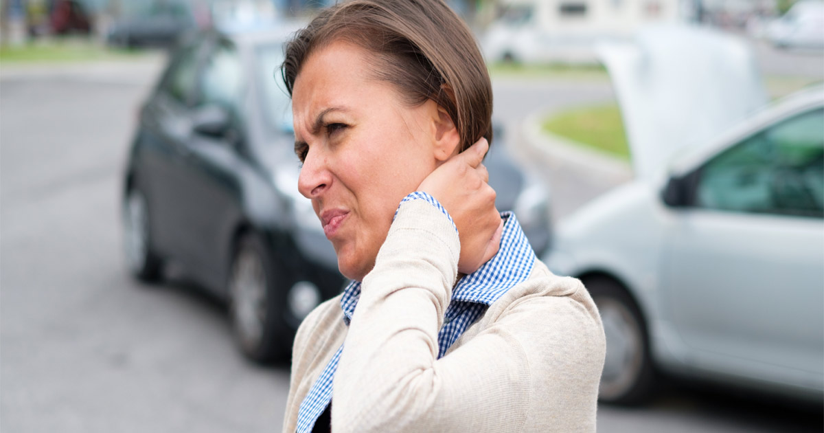 woman holding her neck after car crash